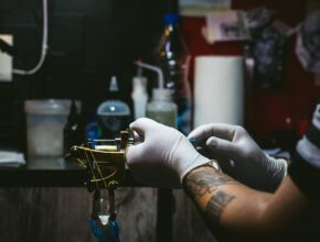 10 cose da sapere prima di fare un tatuaggio: un tatuatore che prepara la macchinetta