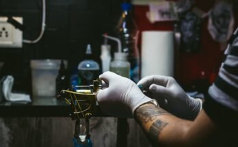 10 cose da sapere prima di fare un tatuaggio: un tatuatore che prepara la macchinetta