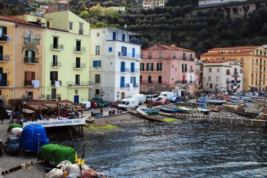Veduta del borgo di pescatori di Marina Grande a Sorrento, con barche colorate e case affacciate sul mare.