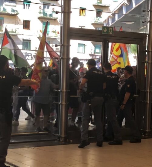 Manifestanti con bandiere palestinesi all'interno della stazione di Napoli Centrale durante lo sciopero per Gaza