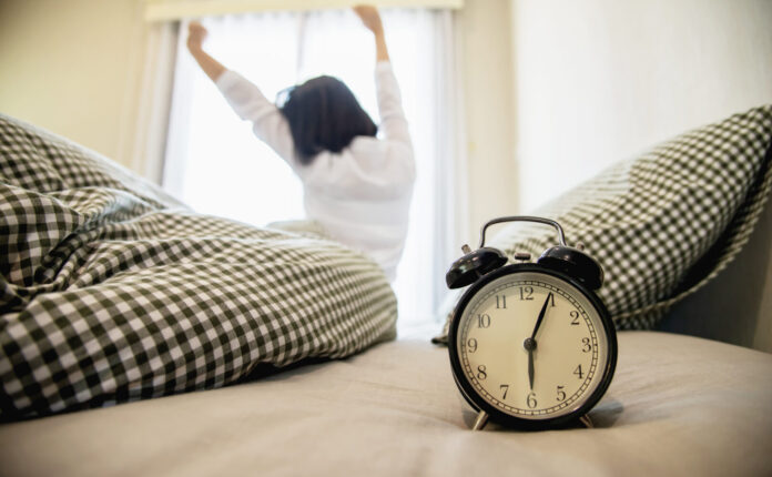 La signora sveglia si allunga pigramente la mattina- migliori abitudini mattutine