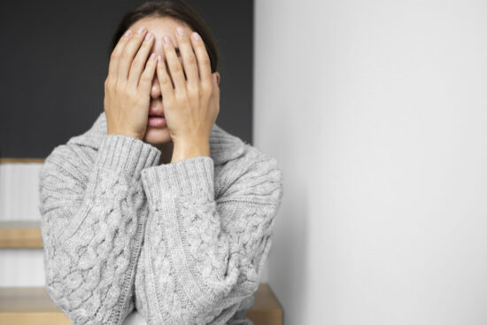 Giovane donna con poca autostima seduta sulle scale