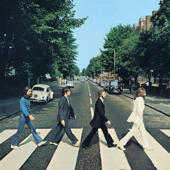 Copertina frontale di Abbey Road dei Beatles. La vista è davvero Abbey Road, Londra, NW8, guardando verso nord. I cancelli degli Abbey Road Studios si trovano dietro il Maggiolino Volkswagen bianco sulla sinistra.